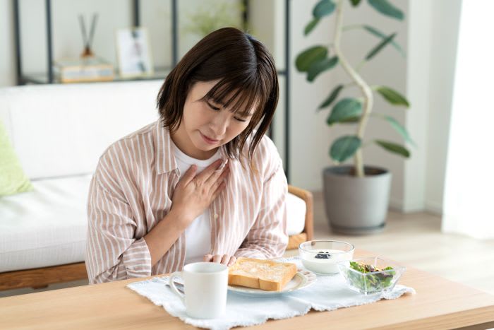 Illustration av halsbränna och sura uppstötningar