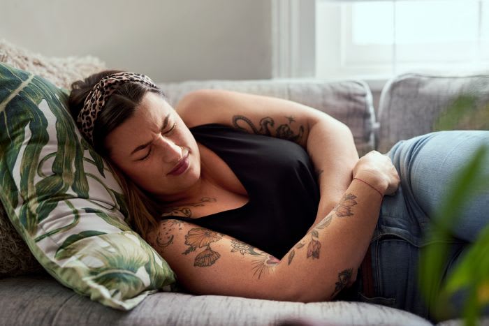 Person som håller om magen vid mensvärk