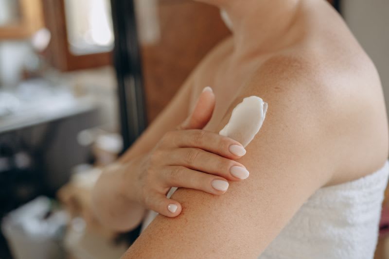 Bild på person som tar på hudkräm