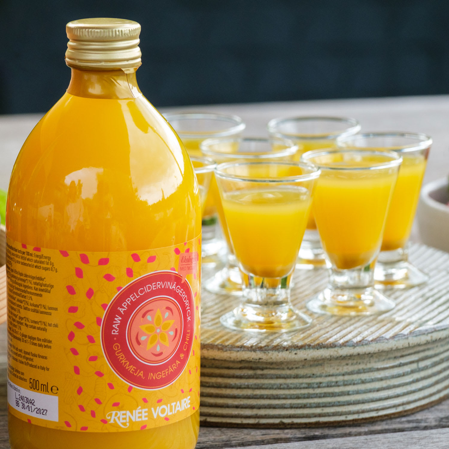 Flaska med gurkmejashot och glas